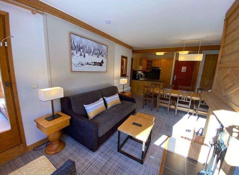 Cozy up in this charming apartment, featuring a comfortable sofa and a warm fireplace.