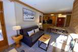 Cozy up in this charming apartment, featuring a comfortable sofa and a warm fireplace.