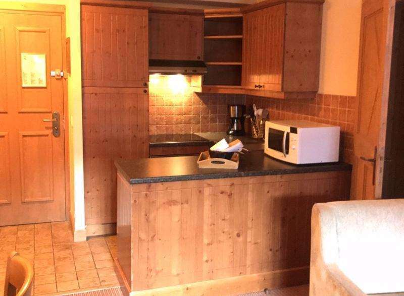 Cozy kitchen with wooden cabinets and a microwave.