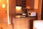 Cozy kitchen with wooden cabinets and a microwave.
