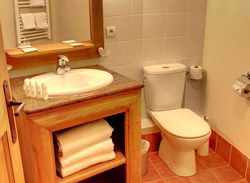 This cozy bathroom features a wooden vanity with a sink and ample storage for towels.