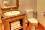 This cozy bathroom features a wooden vanity with a sink and ample storage for towels.
