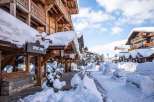 Experience the charm of a snow-covered village with wooden buildings and shops.