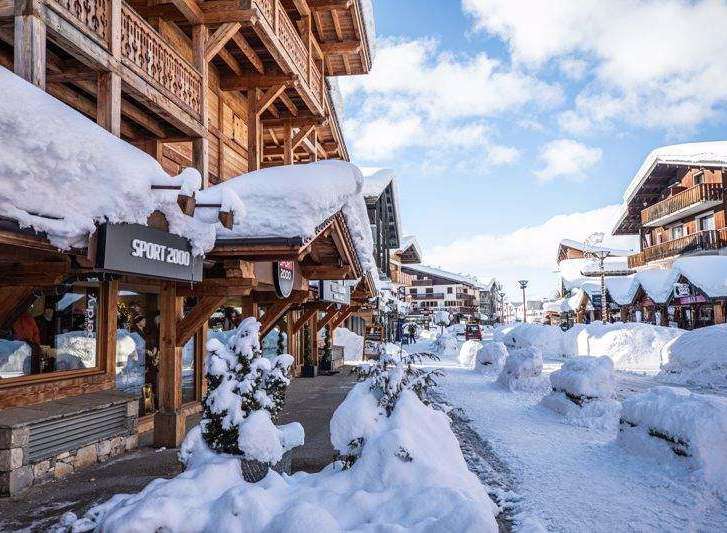 Experience the charm of a snow-covered village with wooden buildings and shops.