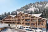 Discover the charm of this stunning wooden chalet nestled in a snowy landscape.