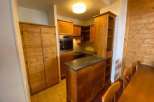 This charming kitchen features warm wooden cabinetry and a cozy dining area.