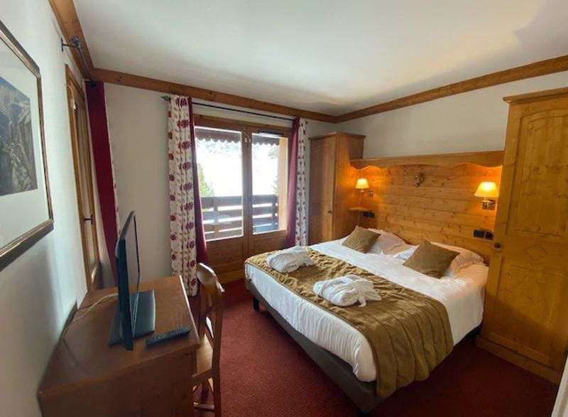 Cozy hotel room featuring a comfortable bed with a warm blanket and plush pillows.
