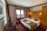 Cozy hotel room featuring a comfortable bed with a warm blanket and plush pillows.
