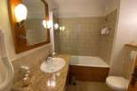 This bathroom features a stylish design with a modern sink and a well-lit vanity area.