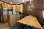 This charming kitchen boasts a rustic design with wooden cabinetry and a stylish dining area.