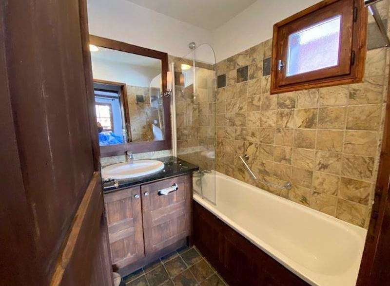 This charming bathroom features a classic design with wooden cabinetry and a matching framed mirror.