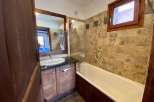 This charming bathroom features a classic design with wooden cabinetry and a matching framed mirror.