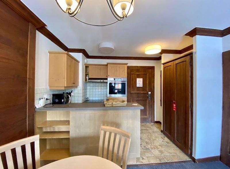 Discover a cozy kitchen with wooden cabinets and a breakfast bar, perfect for preparing meals.