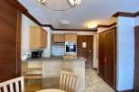 Discover a cozy kitchen with wooden cabinets and a breakfast bar, perfect for preparing meals.