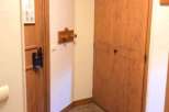 This cozy space features warm wooden doors and a charming tiled floor, creating a welcoming atmosphere.