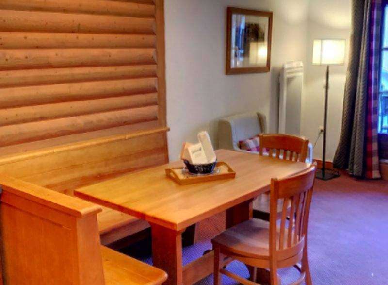 This charming property features a cozy dining area with a wooden table and chairs, perfect for enjoying meals.