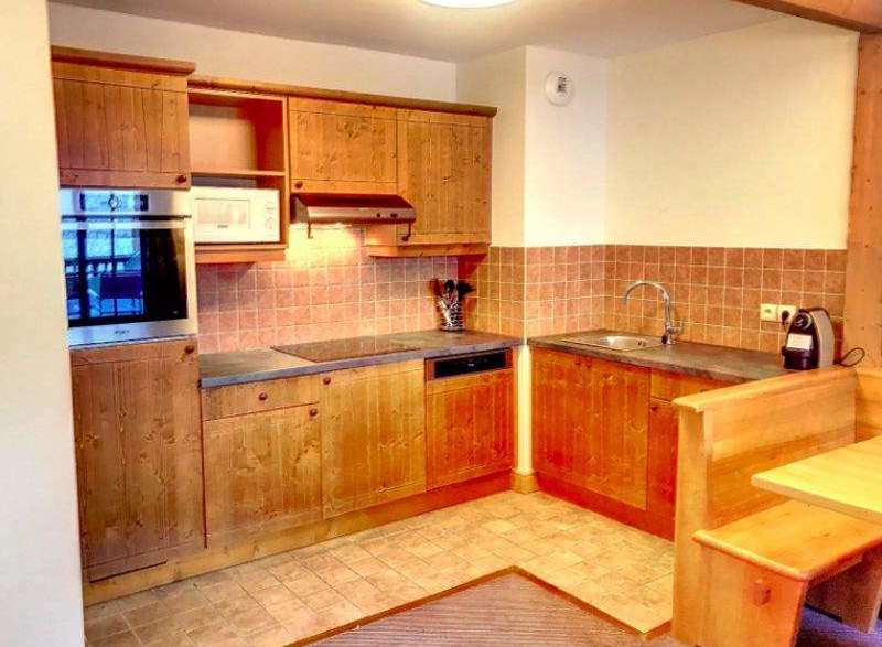 This charming kitchen features warm wooden cabinetry and a cozy dining nook, perfect for enjoying meals.