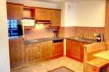 This charming kitchen features warm wooden cabinetry and a cozy dining nook, perfect for enjoying meals.