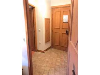Step into this charming entryway featuring a warm wooden door and a convenient built-in cabinet.