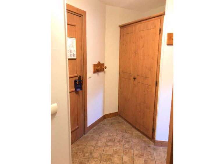 Step into this charming entryway featuring a warm wooden door with a convenient 'Do Not Disturb' sign, perfect for ensuring privacy.