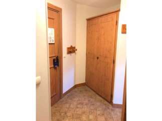 Step into this charming entryway featuring a warm wooden door with a convenient 'Do Not Disturb' sign, perfect for ensuring privacy.