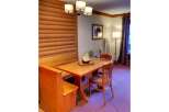 Enjoy cozy meals in this charming dining nook featuring a wooden banquette and a matching table.