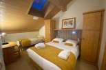 Discover a cozy retreat in this charming room, featuring a comfortable bed and a warm, inviting atmosphere.