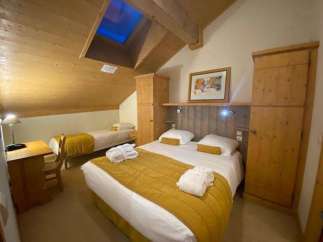 Discover a cozy retreat in this charming room, featuring a comfortable bed and a warm, inviting atmosphere.