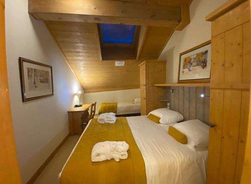 Discover a cozy retreat in this charming bedroom, featuring a unique sloped ceiling and wooden accents.