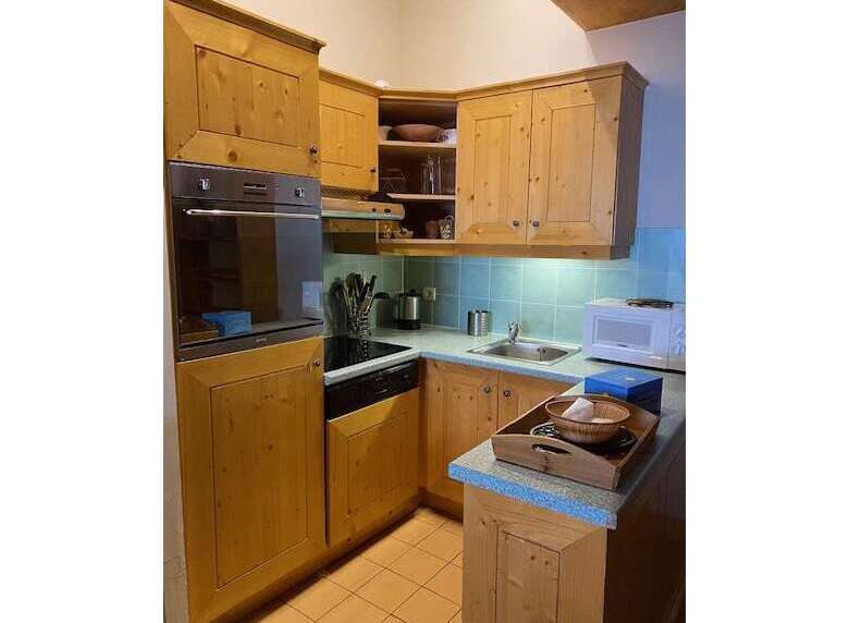 Discover this charming kitchen featuring warm, natural wood cabinetry and a built-in oven and stovetop.