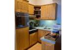 Discover this charming kitchen featuring warm, natural wood cabinetry and a built-in oven and stovetop.