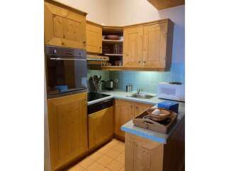 Discover this charming kitchen featuring warm, natural wood cabinetry and a built-in oven and stovetop.