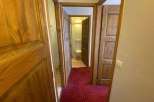 Explore this charming property featuring warm wooden doors and a cozy red carpet.