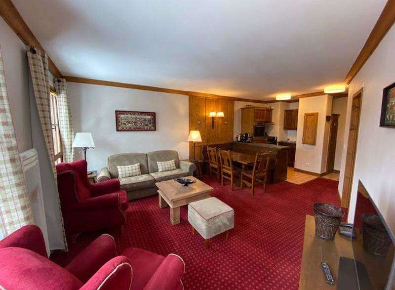 This cozy living space features a warm, inviting atmosphere with its rich red carpet and wooden accents.