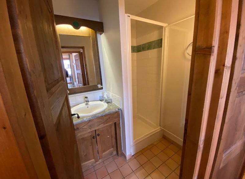 Discover a charming bathroom with a rustic wooden vanity and a sleek shower enclosure.