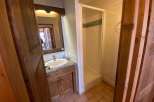 Discover a charming bathroom with a rustic wooden vanity and a sleek shower enclosure.