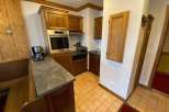 Discover a charming kitchen with wooden cabinetry and a built-in oven, perfect for preparing delicious meals.