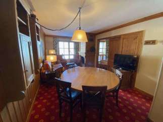This charming property boasts a cozy dining area with a round wooden table, perfect for gatherings.
