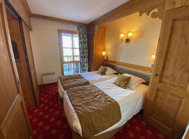 Cozy bedroom featuring two twin beds with plush bedding and decorative pillows.