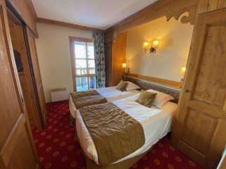 Cozy bedroom featuring two twin beds with plush bedding and decorative pillows.