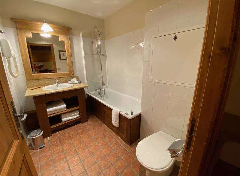 This charming bathroom features a classic design with a wooden vanity and a bathtub.