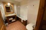 This charming bathroom features a classic design with a wooden vanity and a bathtub.