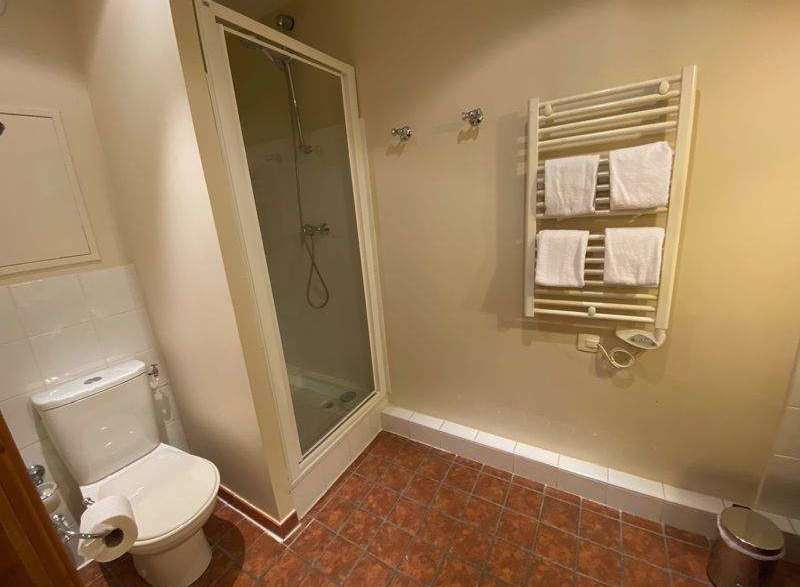 This bathroom features a modern shower with a glass enclosure, perfect for a refreshing start to your day.