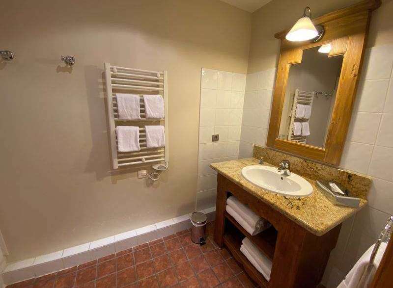 This charming bathroom features a warm, inviting aesthetic with its wooden vanity and granite countertop.