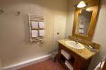 This charming bathroom features a warm, inviting aesthetic with its wooden vanity and granite countertop.
