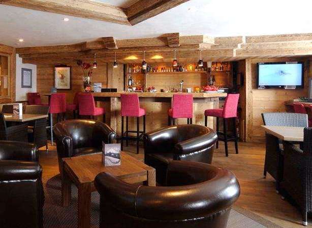 Experience the cozy ambiance of this charming bar, featuring rustic wooden interiors and comfortable seating.