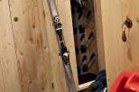 Cozy ski storage room with wooden paneling.