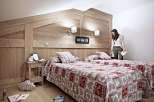 Cozy up in this charming bedroom featuring rustic wooden accents and a warm, inviting atmosphere.