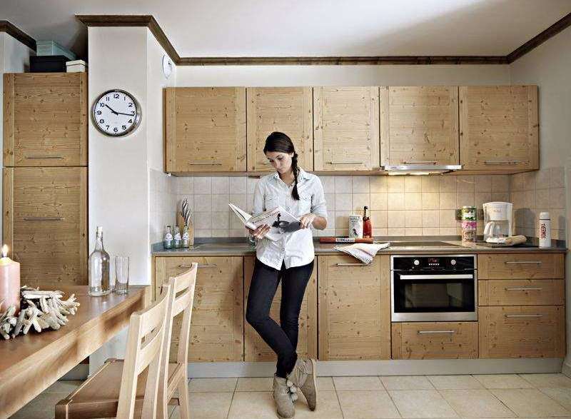 This charming kitchen boasts a warm, inviting atmosphere with its natural wood cabinetry and tiled backsplash.