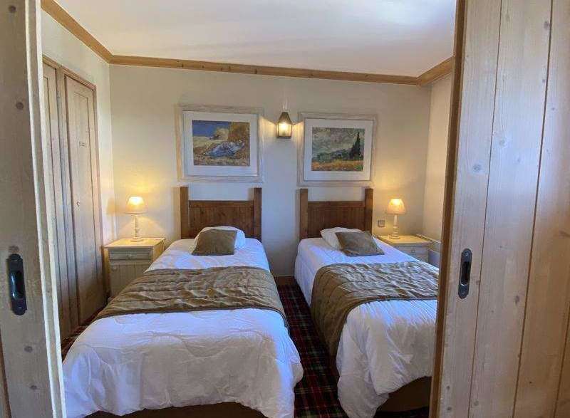 Cozy twin bedroom featuring two comfortable beds with warm bedding, perfect for a relaxing stay.